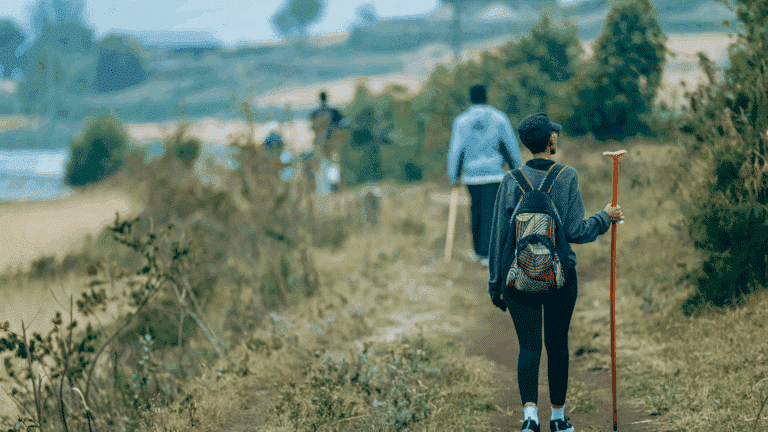 Scenic Outdoor Hiking Pathway Adventure. One person in foreground and several in the background. With walking sticks and backpacks