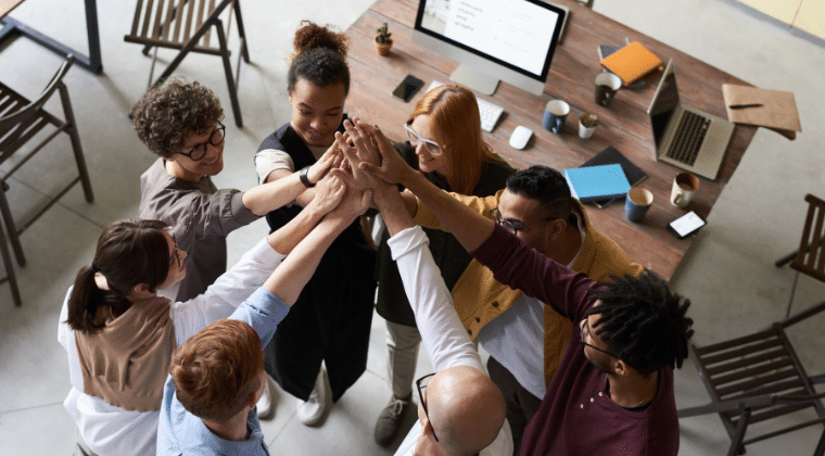 Photo Of People Holding Each Other's Hands and all going in the middle with hands held up. Church Equip Curriculum Healthy Church Meetings